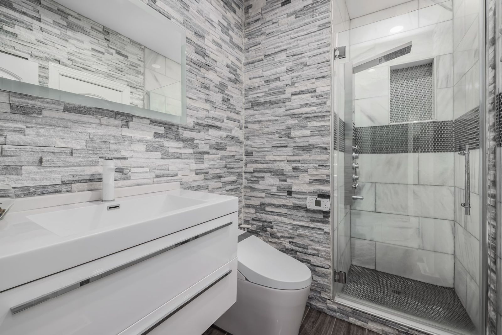 Remodeled bathroom with a tiled walk-in glass shower